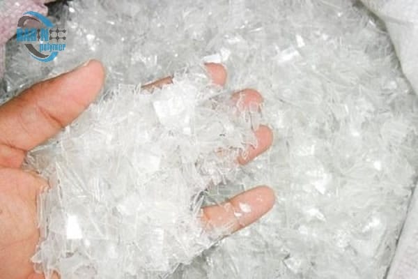 Hot-washed clear PET flakes in hand